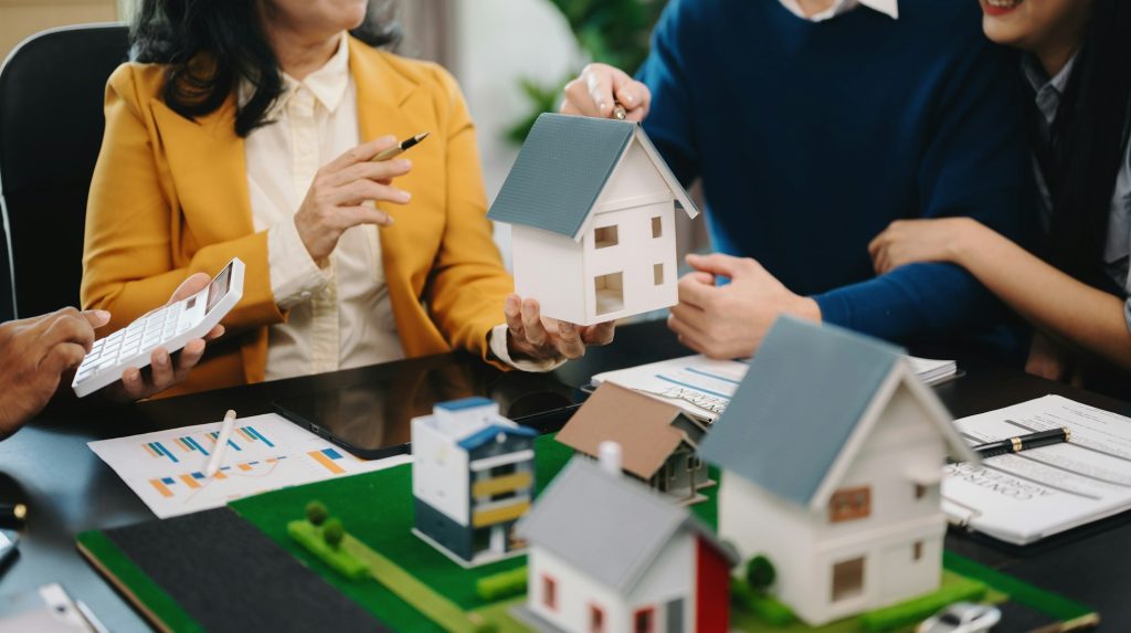 A family couple sign a lease meeting with a realtor or homeowner, purchase the first mortgage
